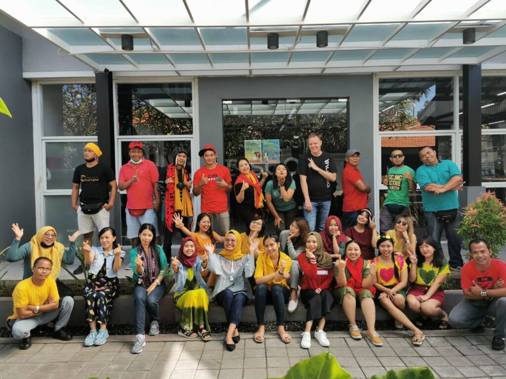 TrovaTrip travelers and locals smiling and posing together in front of store