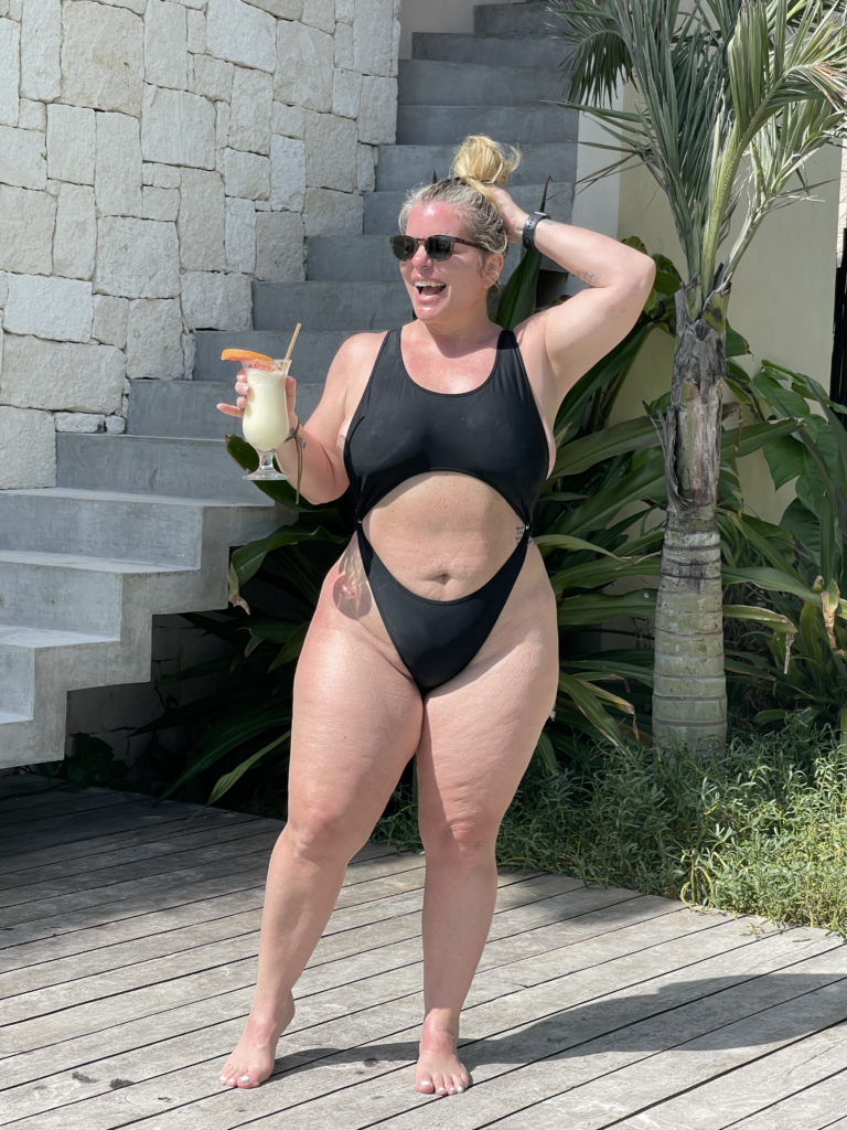 TrovaTrip traveler wearing a black swimsuit holding a cocktail