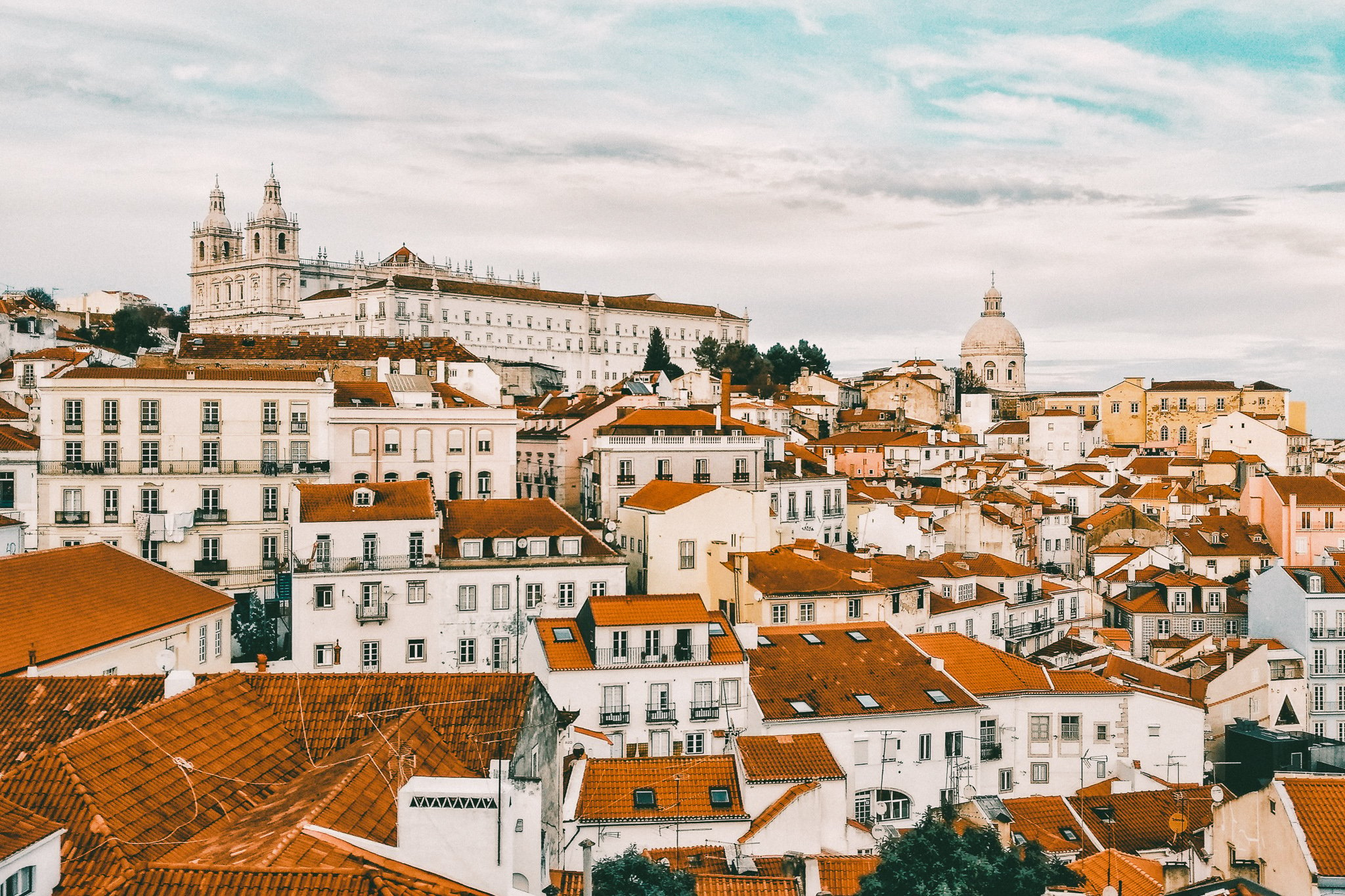 TrovaTrip a collection of homes with white walls and orange roofs in Lisbon, Portugal