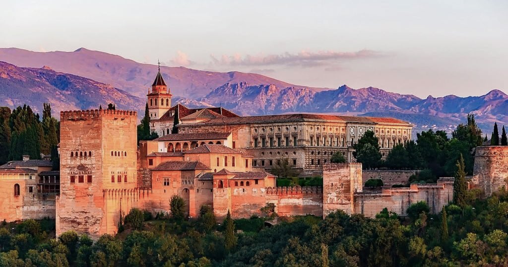 TrovaTrip palace in Spain with sunsetting behind purple mountains