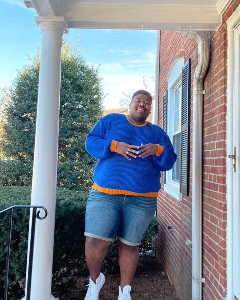 TrovaTrip traveler smiling in blue sweater on front porch