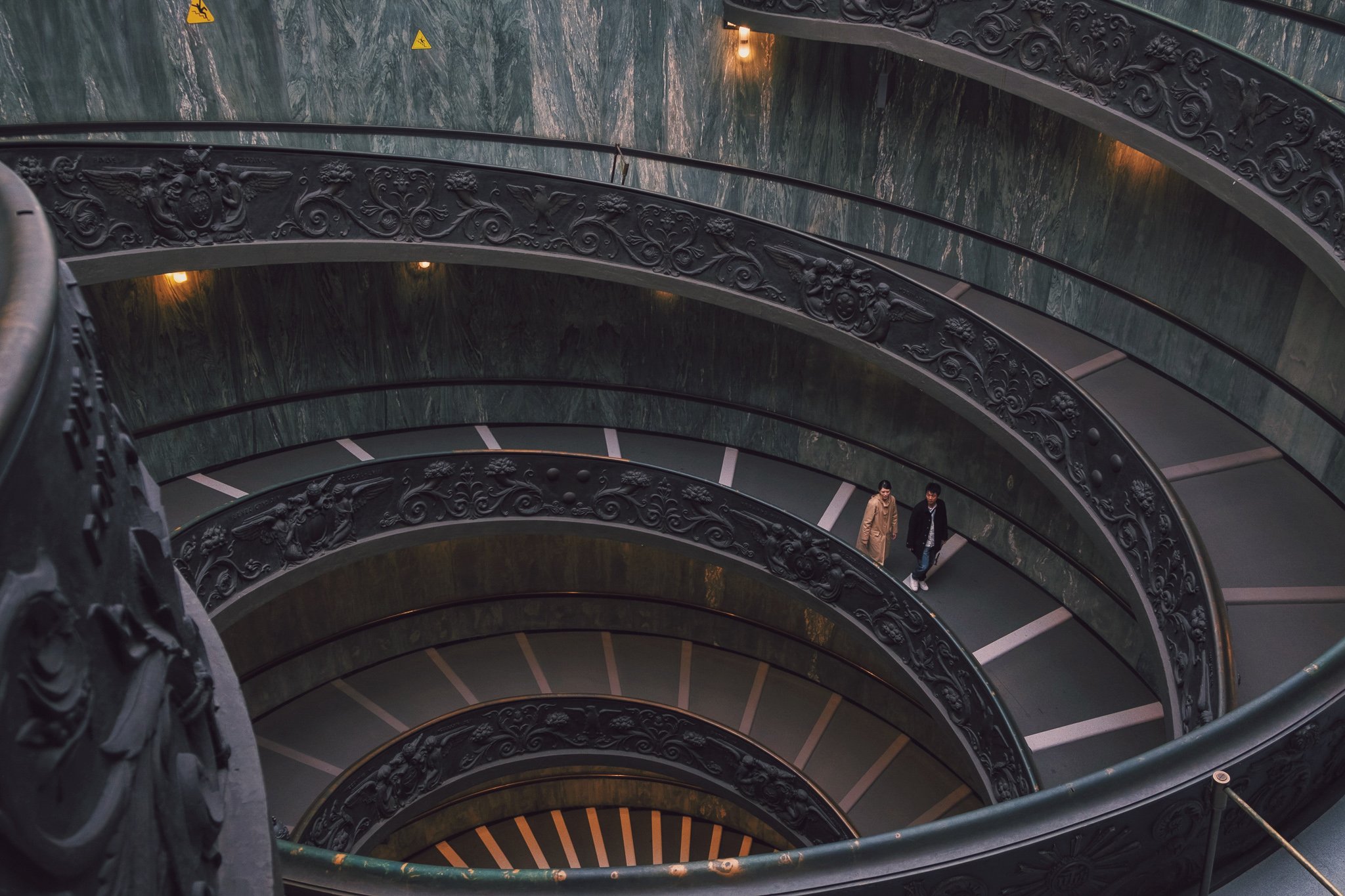 TrovaTrip two people walking down the spiral stairs inside Vatican Museum in Rome 