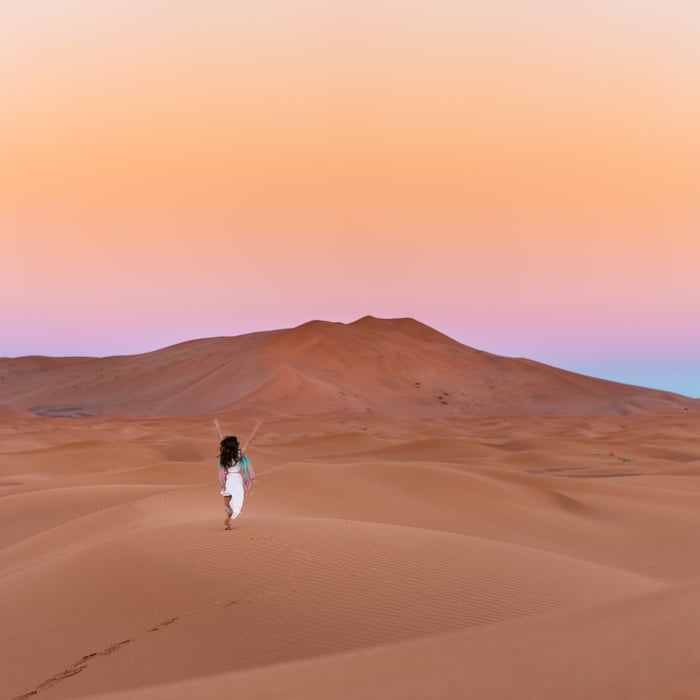 Woman running through desert in Egypt.