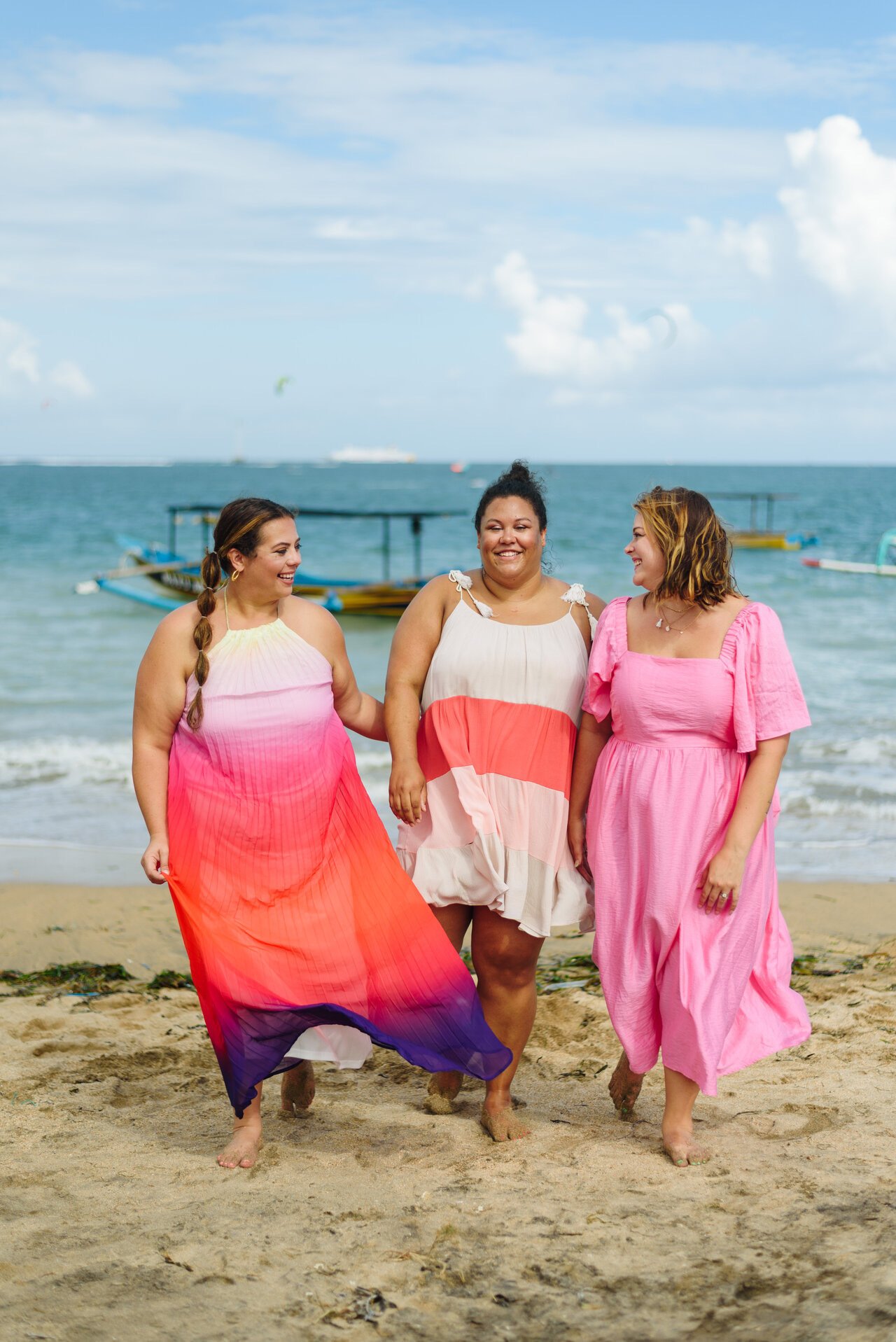 Three women walking on a beach during a group trip to Bali, organized by TrovaTrip.