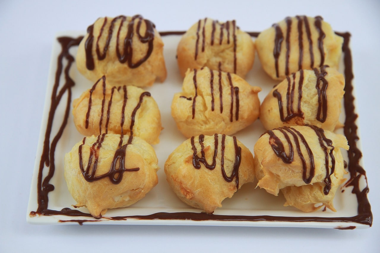 TrovaTrip French Profiteroles lined on a plate with chocolate drizzled on top