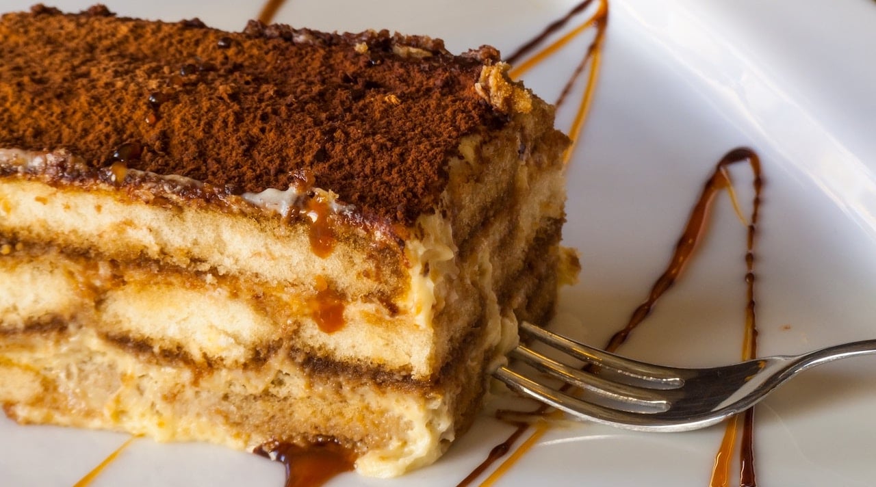 TrovaTrip Tiramisu from Treviso on a plate with a fork touching it