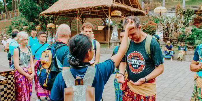 TrovaTrip Bali travelers getting anointed on the head by a local