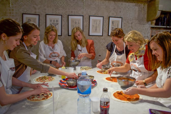 Helene and Travelers in Italy taking a pizza making class.
