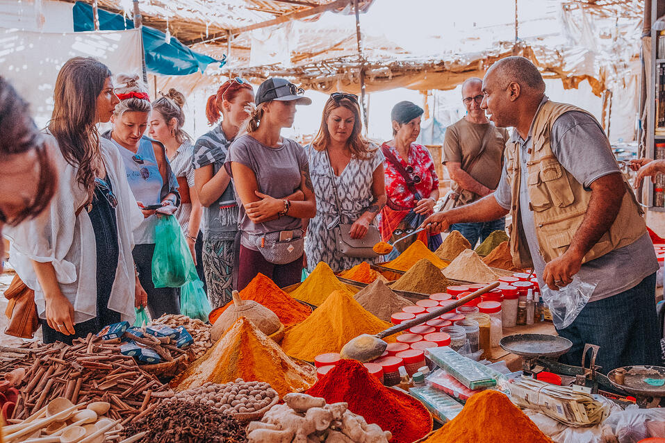 Local Guide showing spices to a group of TrovaTrip Travelers in Morocco.