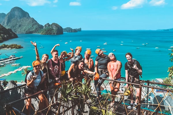 TrovaTrip group wearing helmets and posing in front of ocean