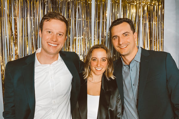TrovaTrip founders, Nick Poggi, Lauren Schneider and Brandon Denham smiling in group photo.