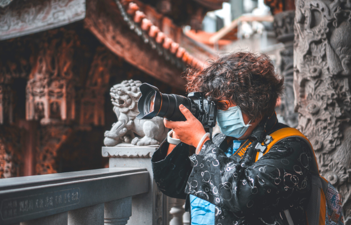 Person wearing a mask during Covid, taking travel photos.