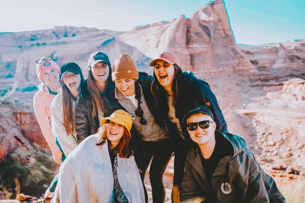 TrovaTrip group of travelers laughing in Utah canyon