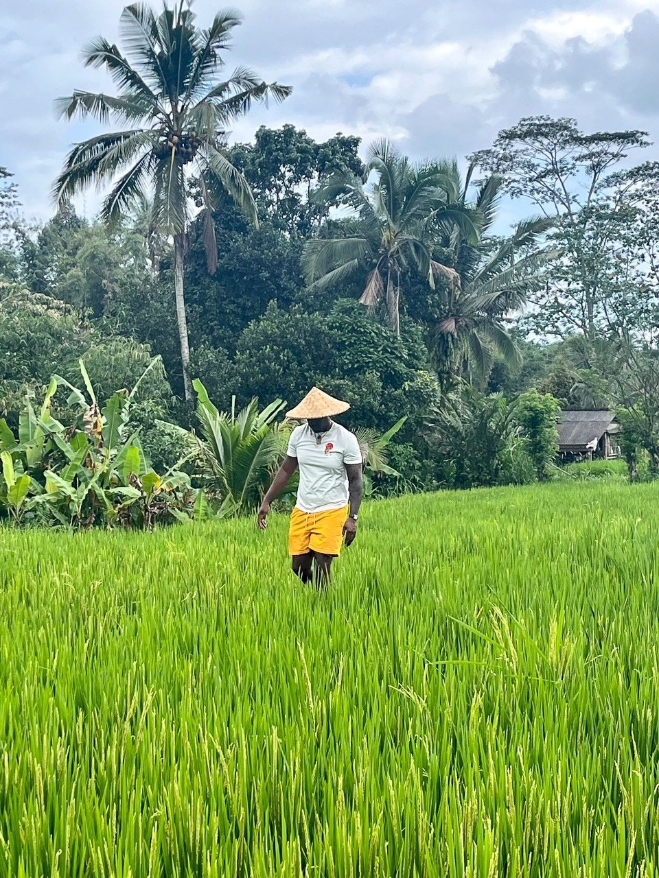Group travel trip Host, iromealot, walking in a field during his group trip to Bali.