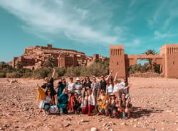 TrovaTrip Morocco group of travelers smiling in front of monument