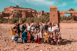 TrovaTrip Morocco group of travelers smiling at camera in front of monument