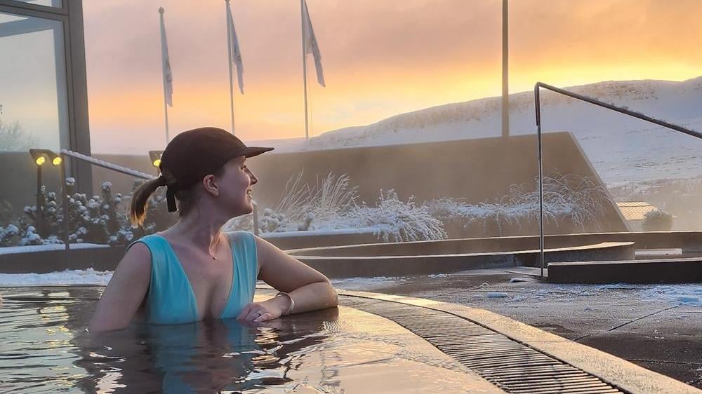Woman sitting in a thermal pool in Iceland, one of the best places to visit in January.