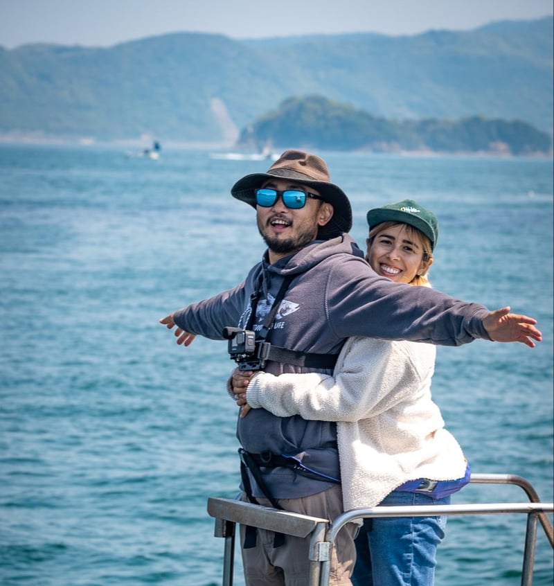 Two people posting near ocean in Japan with @outdoorcheflife.
