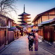 TrovaTrip Japan two women in kimonos with sun setting over Japanese temple