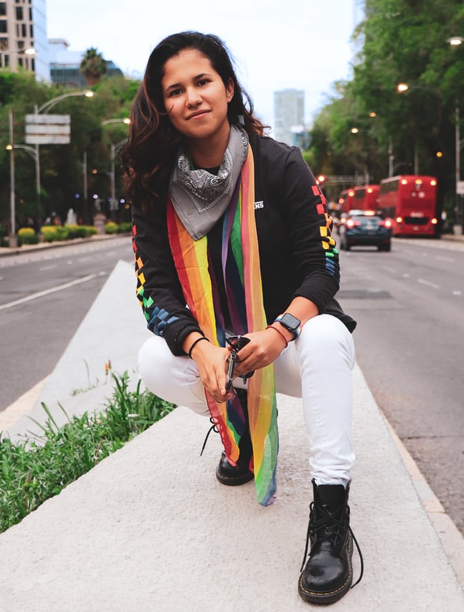 Person wearing a rainbow Pride flag scarf.