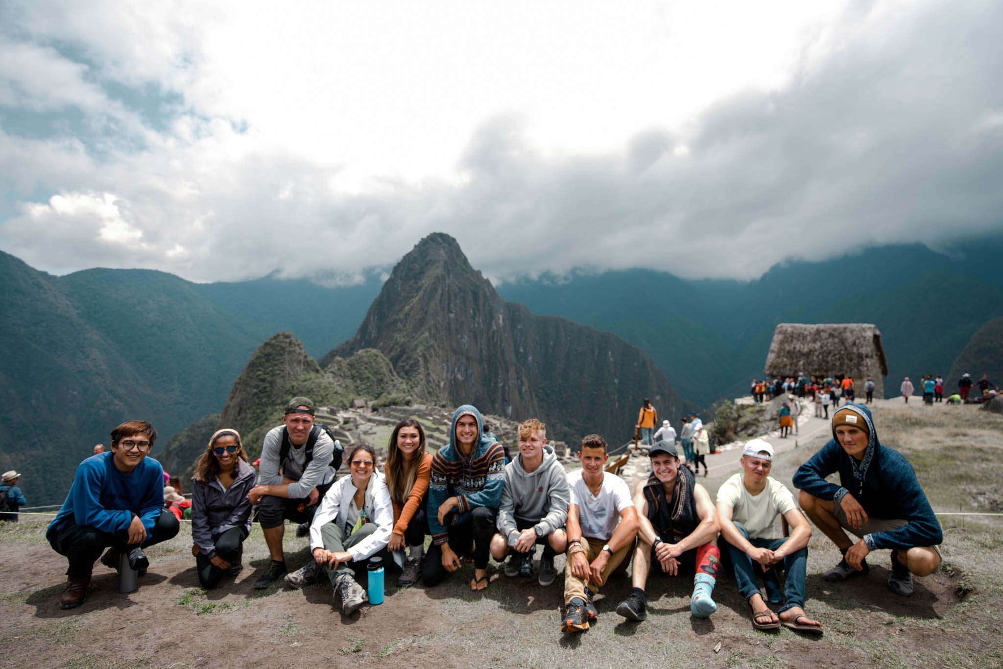 TrovaTrip group of travelers sitting down in front of Machu Picchu in Peru