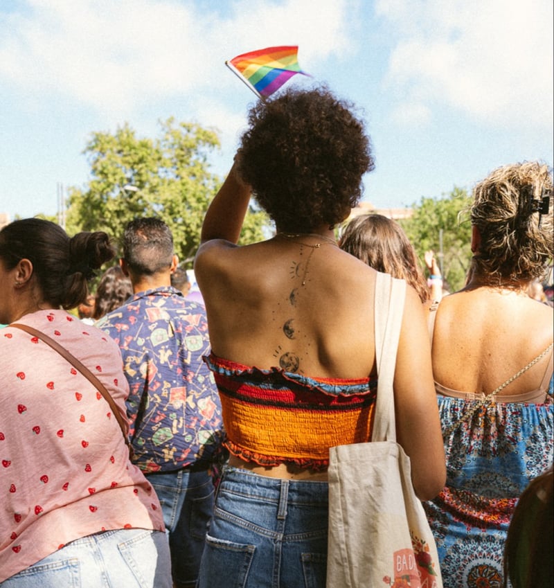 Person holding up rainbow flag during Pride.
