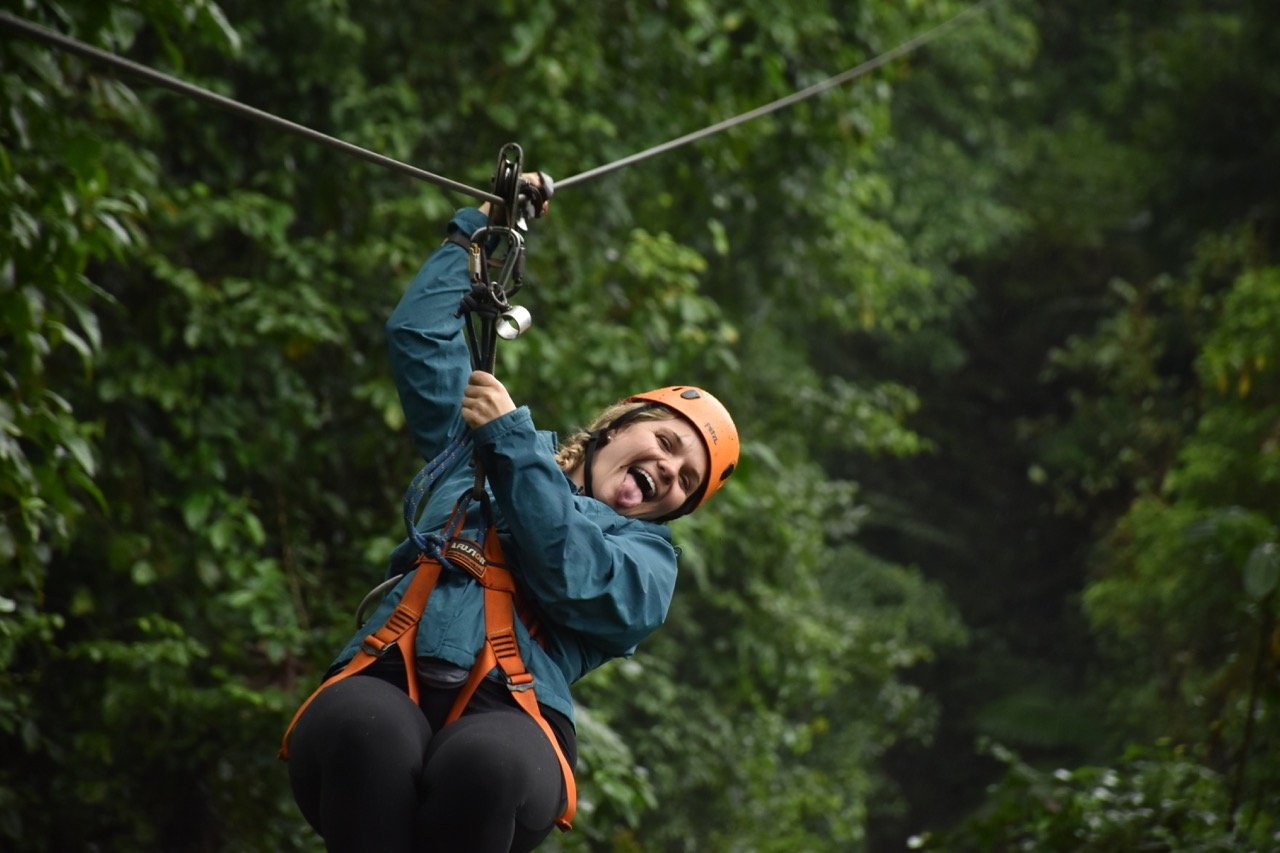 A traveler ziplining during a group trip to Costa Rica through TrovaTrip.