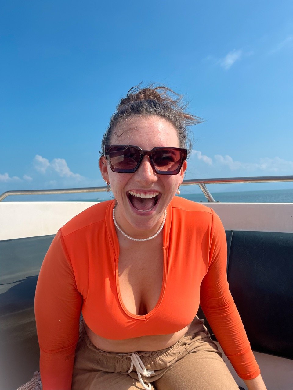 A Traveler on a boat smiling during a group trip in Bali with TrovaTrip.