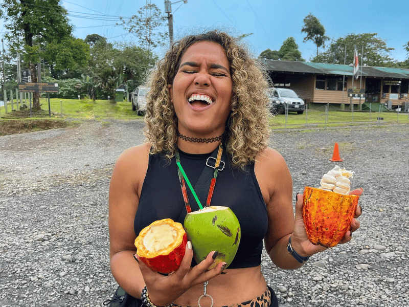 TrovaTrip Traveler holding fruit and laughing.