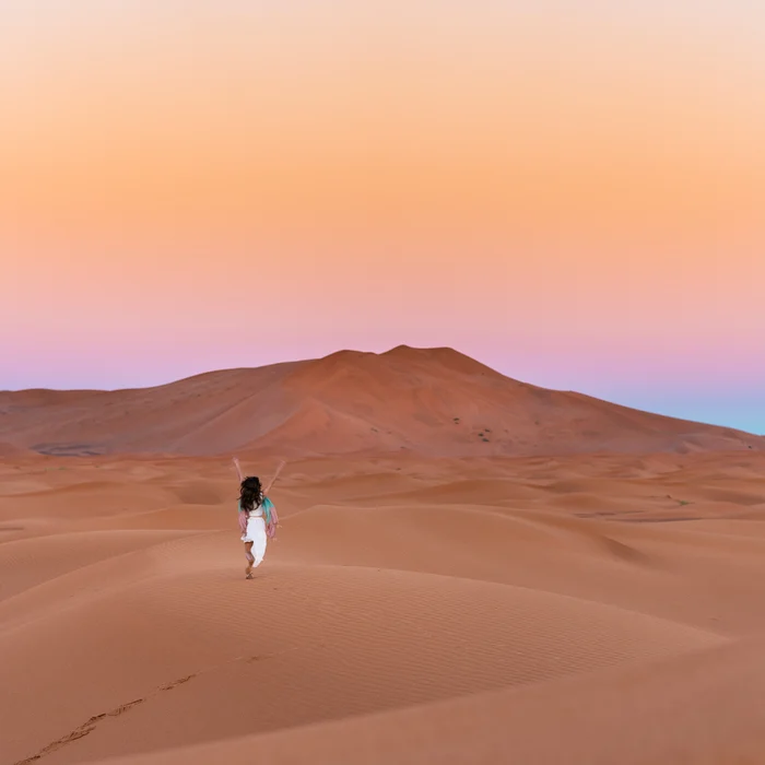 Woman running through desert in Egypt