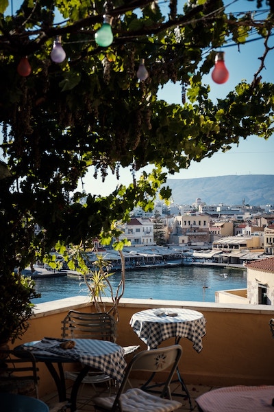 Outdoor tables and chairs overlooking the water in Chania, Greece.